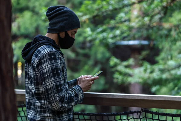 Jeune Homme Tenant Téléphone Portable Portant Masque Sur Environnement Naturel — Photo