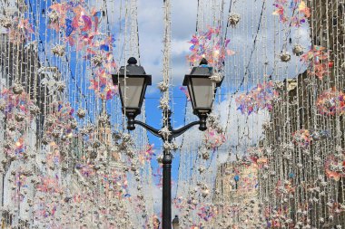 Nikolskaya Moskova Rusya sokakta güneşte parlayan renkli çelenk arka planda siyah beyaz fener