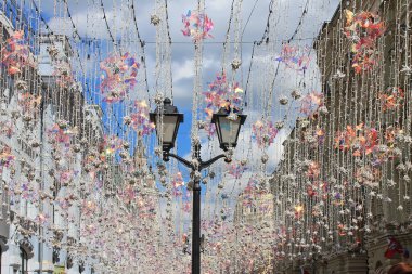 Nikolskaya Moskova Rusya sokakta güneşte parlayan renkli çelenk arka planda siyah beyaz fener