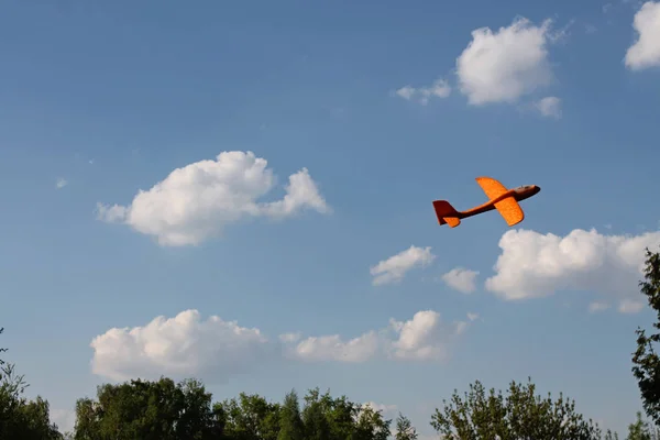 Avião Espuma Laranja Flutuando Contra Fundo Nuvens Brancas Céu Azul — Fotografia de Stock