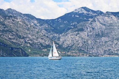 Turkuaz su beyaz yat ve bankalarda yeşil dağlar ile Göl Garda İtalya yaz manzara