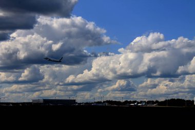 Bulutlarla mavi gökyüzünde uçan uçak
