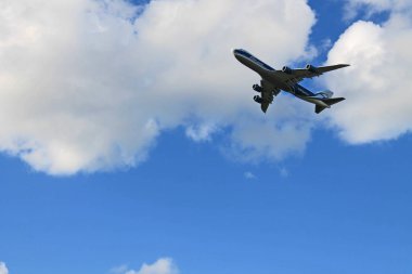 Bulutlarla mavi gökyüzünde uçan uçak