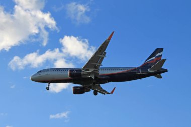 Bulutlarla mavi gökyüzünde uçan uçak