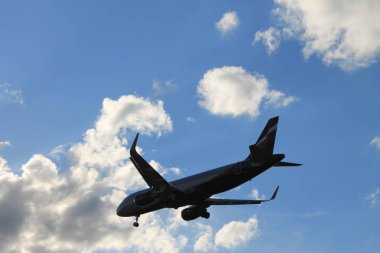 Bulutlarla mavi gökyüzünde uçan uçak