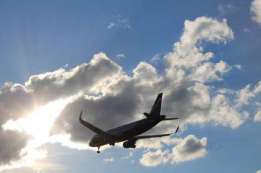 Bulutlarla mavi gökyüzünde uçan uçak