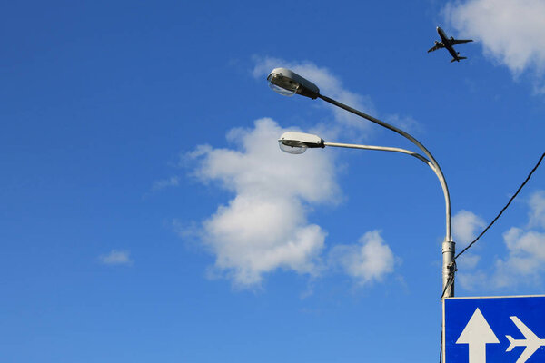 Flying plane in the blue sky with clouds
