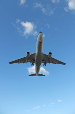 Bulutlarla mavi gökyüzünde uçan uçak