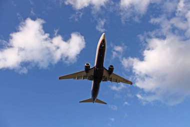 Bulutlarla mavi gökyüzünde uçan uçak