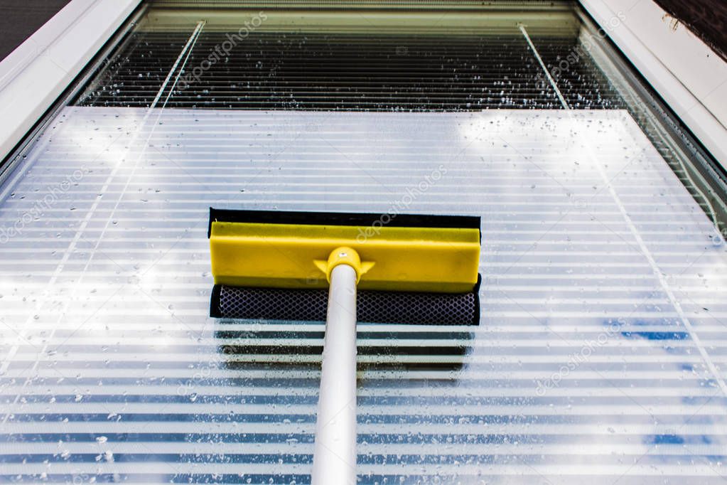 Washing plastic Windows with a yellow brush