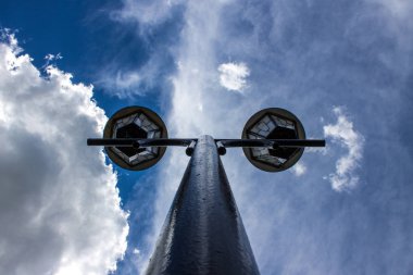 Beyaz bulutlar ile saf mavi gökyüzü bir arka plan üzerinde yüksek bir kutup üzerinde Sokak lambası yakın çekim