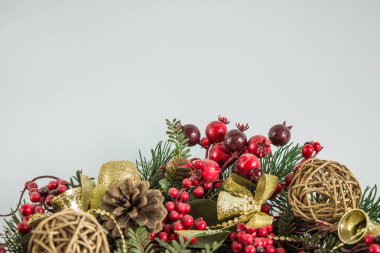 Nötr bir arka plan üzerinde cam oyuncaklar ve köknar dalları ile parlak renkli Noel süslemeleri