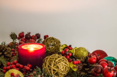 Nötr bir arka plan üzerinde cam oyuncaklar ve köknar dalları ile parlak renkli Noel süslemeleri