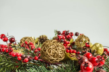 Nötr bir arka plan üzerinde cam oyuncaklar ve köknar dalları ile parlak renkli Noel süslemeleri