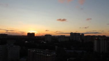 Uzun evler ve bulutlu gökyüzü ile şehir üzerinde gündoğumu