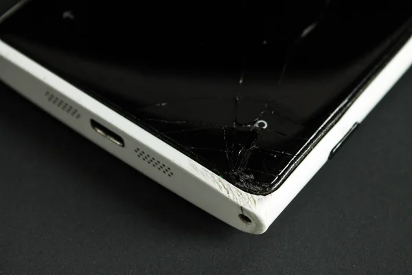 Broken screen smartphone with a cracked screen closeup