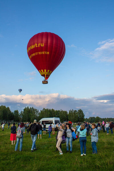 Pereslavl-Zalessky, Yaroslavl region / Russia - July, 20, 2019: flying an air balloon with passengers in a basket against the blue sky at the Aeronautics Festival on a summer evening