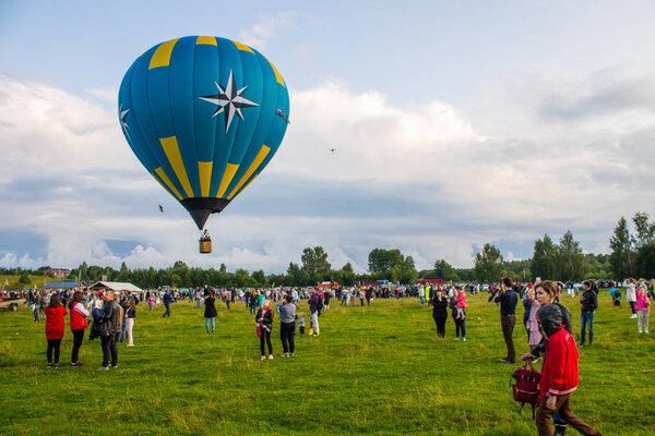 Pereslavl-Zalessky, Yaroslavl region / Russia - July, 20, 2019: Warming up at the start of balloons and take-off with passengers in a basket at the Aeronautics Festival on a summer evening in front of a large audience