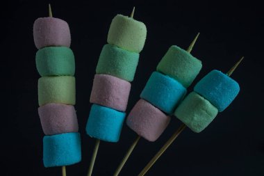 Gri arka plan üzerinde bir sopa üzerinde çok renkli marshmallow