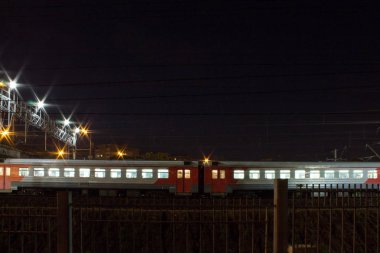 Moskova Rusya 'da novogireevo Tren İstasyonu gece yol Köprüsü altında geçen bir tren ile