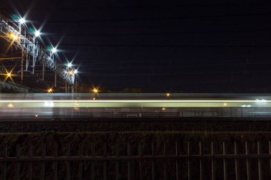 Moskova Rusya 'da novogireevo Tren İstasyonu gece yol Köprüsü altında geçen bir tren ile
