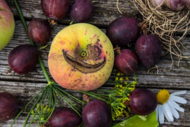 Eski ahşap bir masada Elma bezelye ve papatya ile natürmort