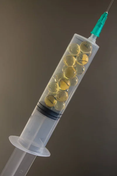오메가 비타민이 함유된 노란색 캡슐로 채워진 주사기 — 스톡 사진