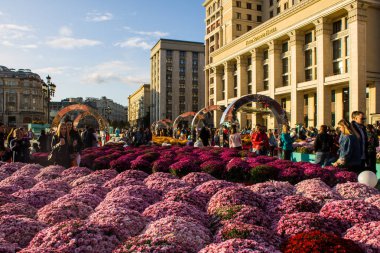 Moskova, Rusya - 14 Eylül 2019: tarihi mimarisi ile şehir merkezinde dev çiçek yatakları ve turistler, açık bir gün