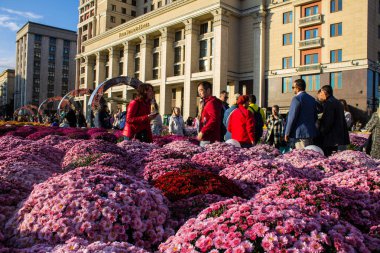 Moskova, Rusya - 14 Eylül 2019: tarihi mimarisi ile şehir merkezinde dev çiçek yatakları ve turistler, açık bir gün