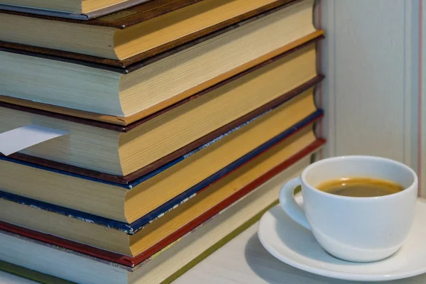 一堆书和一杯咖啡在白色的桌子上 — 图库照片