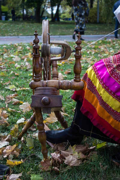 woman in Russian national costume with spinning wheel and spindle