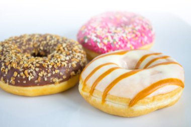 Renkli kremalı ve soslu üç çörek.