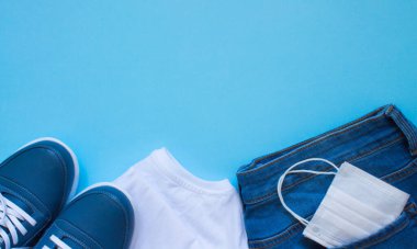 Koruyucu ekipmanlı temel günlük kıyafetler - tıbbi maske ve lastik eldivenler mavi arka plan ve kopyalama alanı üzerine yakın plan