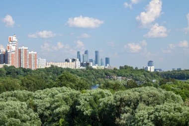 Moskova 'daki modern yerleşim binalarının panoramik manzarası açık güneşli bir yaz gününde yeşil ağaçlarla bir kopya alanı