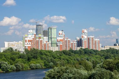 Moskova 'daki modern yerleşim binalarının panoramik manzarası açık güneşli bir yaz gününde yeşil ağaçlarla bir kopya alanı