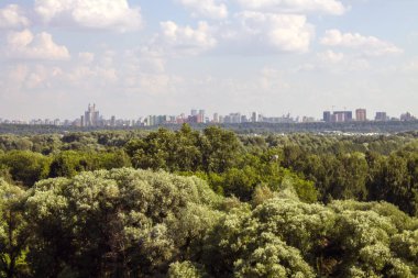 Moskova 'daki modern yerleşim binalarının panoramik manzarası açık güneşli bir yaz gününde yeşil ağaçlarla bir kopya alanı
