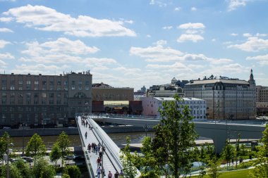 Moskova 'nın tarihi merkezindeki Zaryadye Parkı' ndaki Moskova nehri ve Yükselen Köprü 'nün panoramik manzarası güneşli bir yaz gününde