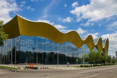 Moskova Rusya 'daki modern ritmik jimnastik sarayı, cam duvarlarda mutlulukla mavi gökyüzünü kopyalamak için yer kaplıyor.