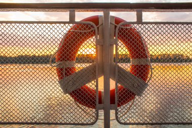 Geminin güvertesinden gün batımının can simidinden görünüşü. Seyahatleri algıla ve uzayı kopyala