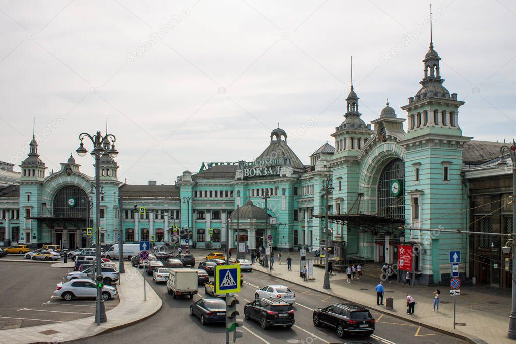 green historical building Belorussky railway station and transport Parking on the background of a cloudy sky and space for copying in Moscow Russia