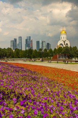Zafer Parkı 'ndaki Poklonnaya tepesindeki Aziz George Kilisesi ve Moskova şehrinin modern binalarının manzarası.