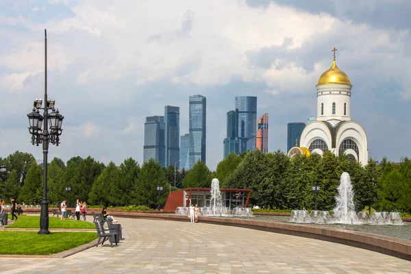 Zafer Parkı 'ndaki Poklonnaya tepesindeki Aziz George Kilisesi ve Moskova şehrinin modern binalarının manzarası.