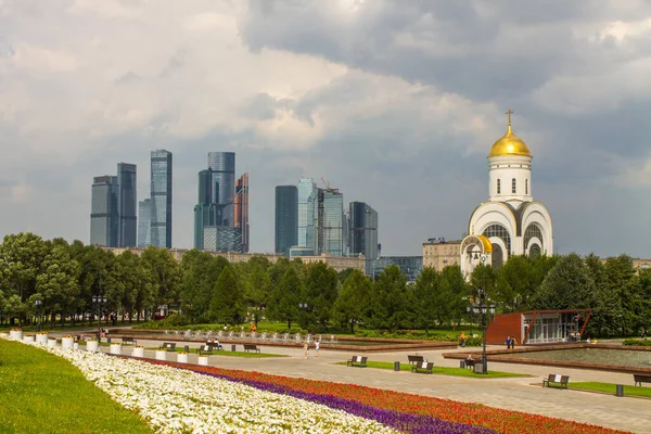 Zafer Parkı 'ndaki Poklonnaya tepesindeki Aziz George Kilisesi ve Moskova şehrinin modern binalarının manzarası.
