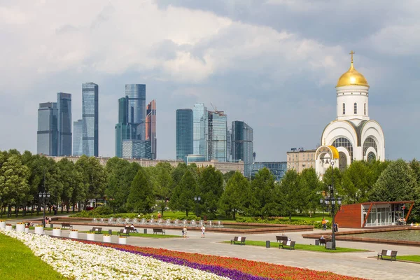 Zafer Parkı 'ndaki Poklonnaya tepesindeki Aziz George Kilisesi ve Moskova şehrinin modern binalarının manzarası.