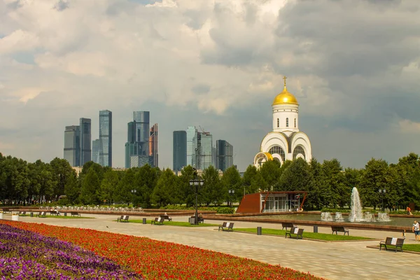 Zafer Parkı 'ndaki Poklonnaya tepesindeki Aziz George Kilisesi ve Moskova şehrinin modern binalarının manzarası.