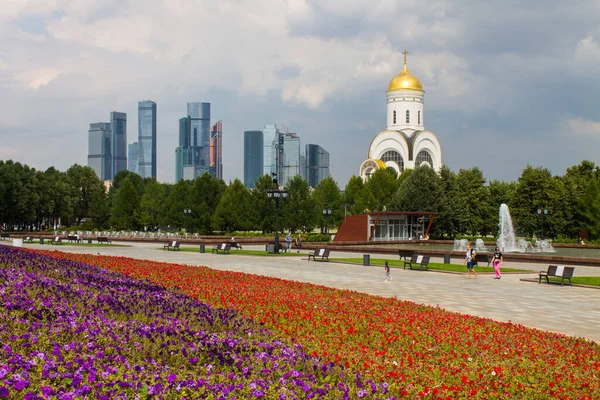 Zafer Parkı 'ndaki Poklonnaya tepesindeki Aziz George Kilisesi ve Moskova şehrinin modern binalarının manzarası.