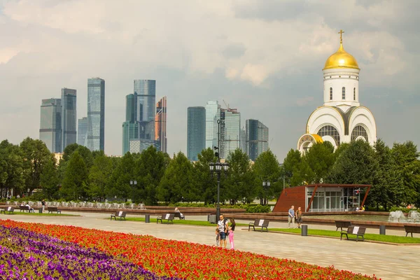 Zafer Parkı 'ndaki Poklonnaya tepesindeki Aziz George Kilisesi ve Moskova şehrinin modern binalarının manzarası.