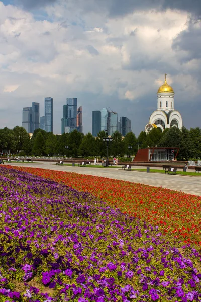 Zafer Parkı 'ndaki Poklonnaya tepesindeki Aziz George Kilisesi ve Moskova şehrinin modern binalarının manzarası.