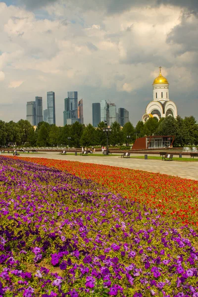 Zafer Parkı 'ndaki Poklonnaya tepesindeki Aziz George Kilisesi ve Moskova şehrinin modern binalarının manzarası.