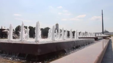 Moskova Rusya 'da açık bir yaz gününde Poklonnaya tepesindeki anıt kule manzaralı su çeşmesi.